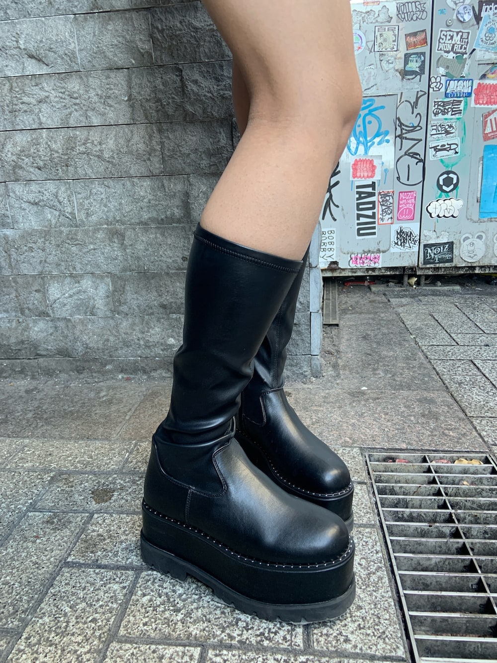 ブラウン系のニット/セーター、ブラック系のその他パンツ、ブラック系のブーツを着用したレディースの冬コーディネートの6枚目の写真