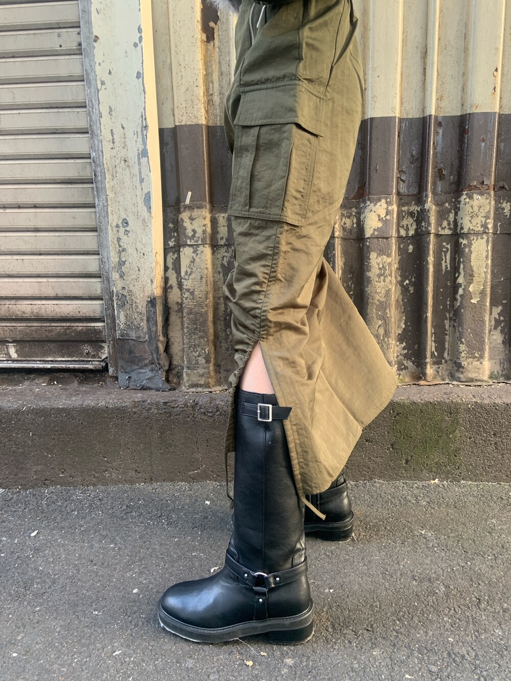 ブルー系のニット/セーター、ブラック系のボストンバッグ、グリーン系のスカートを着用したレディースの冬コーディネートの8枚目の写真