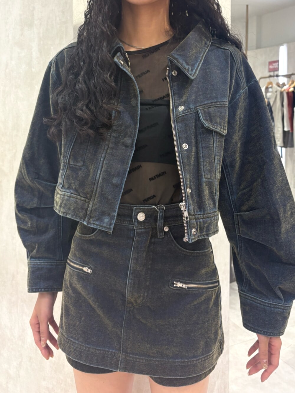 グリーン系のデニムジャケット、グリーン系のデニムスカート、ブラック系のTシャツ/カットソーを着用したレディースの夏コーディネートの4枚目の写真