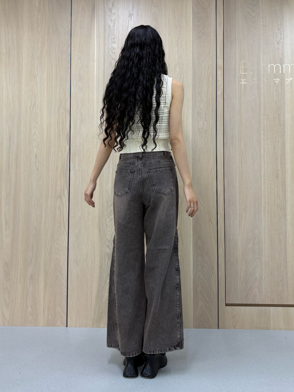 ホワイト系のタンクトップ、ブラック系のデニムパンツ、グリーン系のサンダルを着用したレディースの春コーディネートの3枚目の写真
