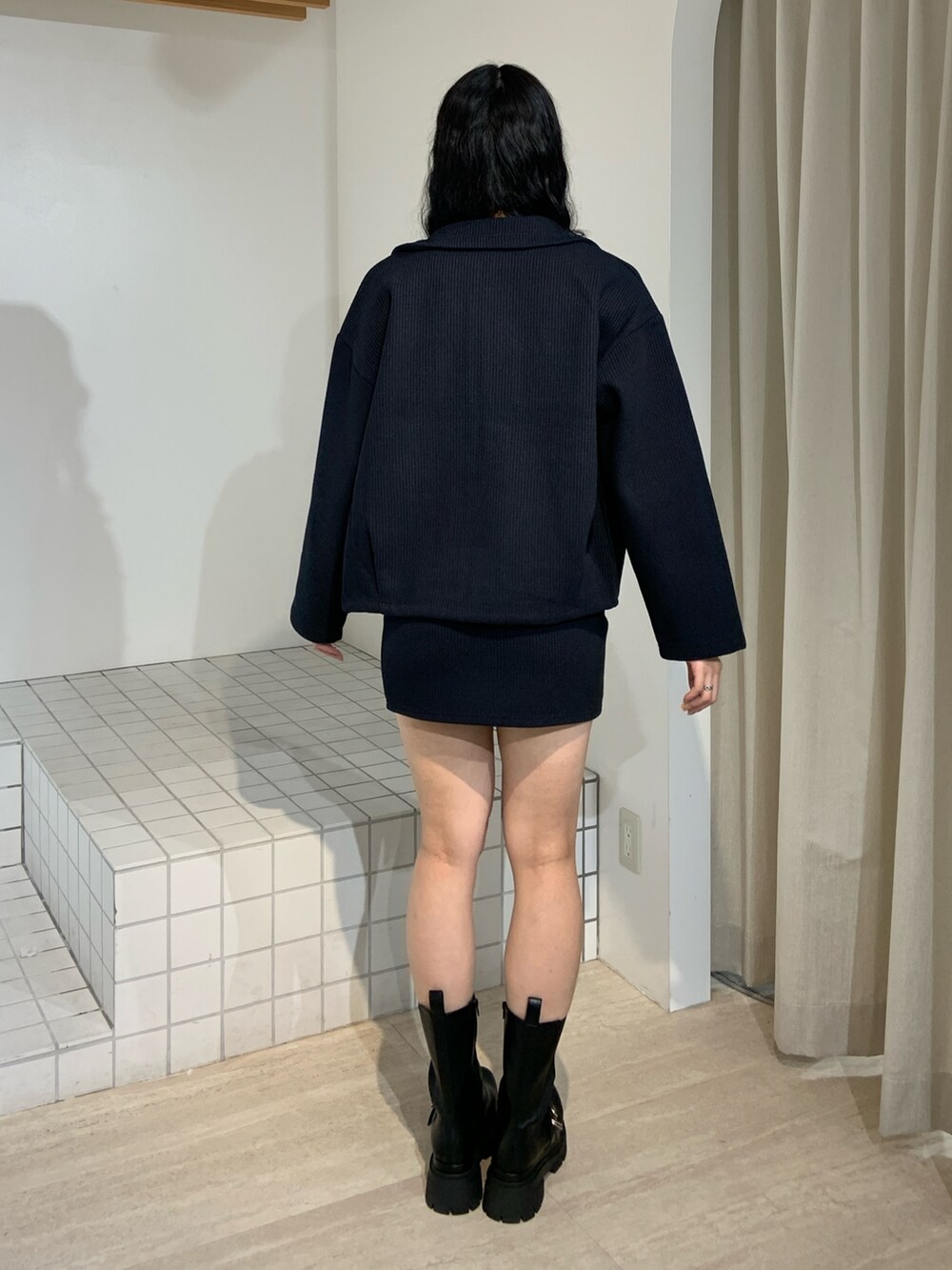 ブルー系のブルゾン、ブルー系のスカート、ブラック系のブーツを着用したレディースの秋コーディネートの3枚目の写真