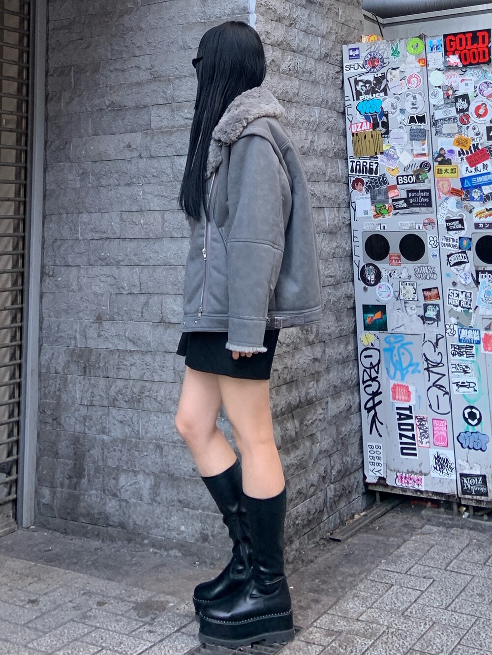 グレー系のムートンコート、ブルー系のニット/セーター、ブラック系のその他パンツを着用したレディースの冬コーディネートの3枚目の写真