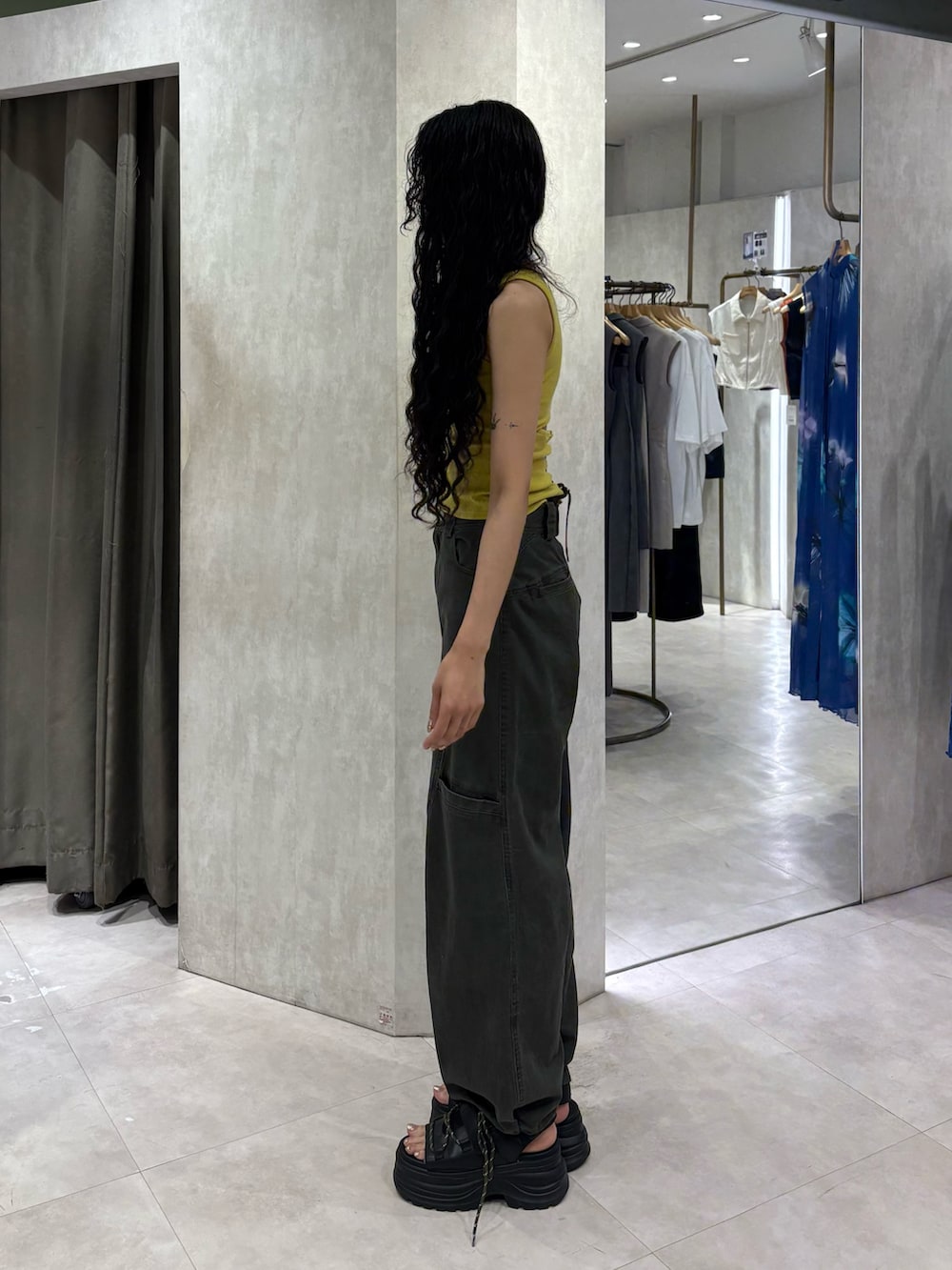 イエロー系のタンクトップ、グリーン系のその他パンツ、ブラック系のサンダルを着用したレディースの夏コーディネートの2枚目の写真