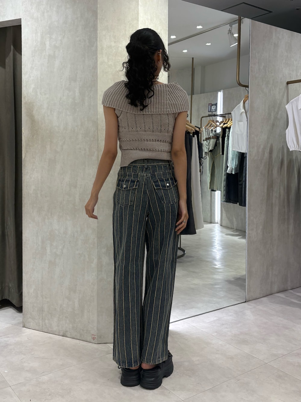 ベージュ系のニット/セーター、ブルー系のデニムパンツ、ブラック系のサンダルを着用したレディースの夏コーディネートの3枚目の写真