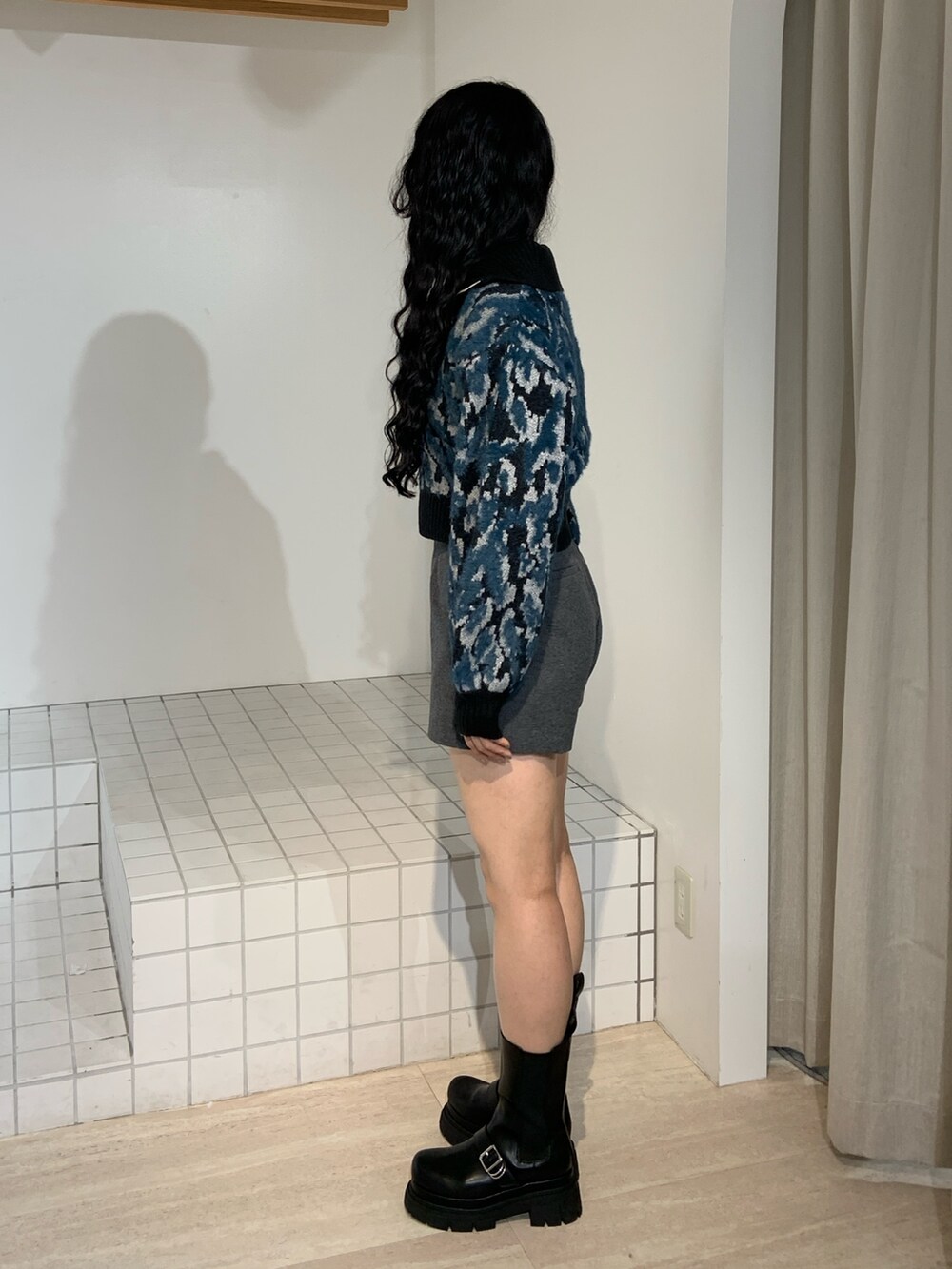 ブラック系のニット/セーター、グレー系のその他パンツ、ブラック系のブーツを着用したレディースの秋コーディネートの2枚目の写真