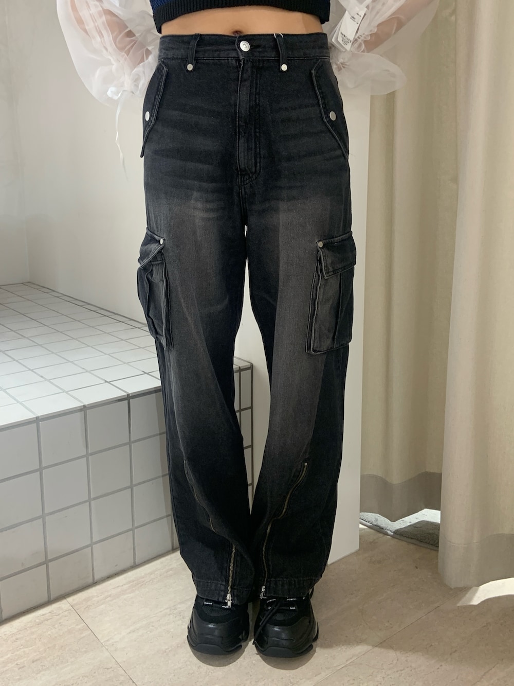 ブラウン系のブルゾン、ブルー系のタンクトップ、ブラック系のデニムパンツを着用したレディースの春コーディネートの6枚目の写真