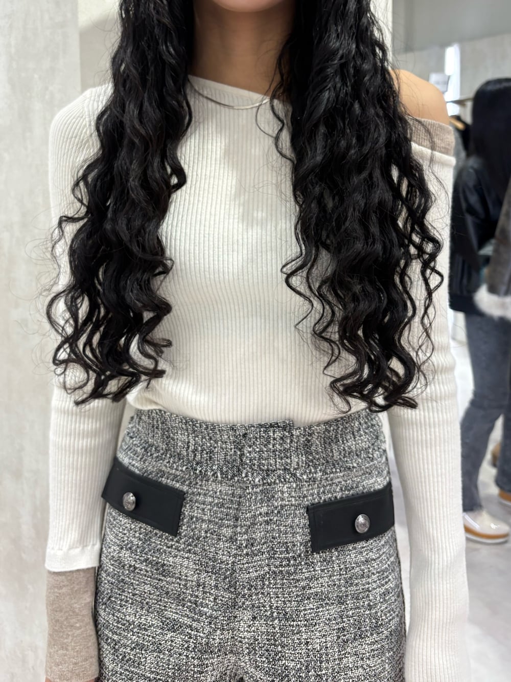 ホワイト系のニット/セーター、グレー系のその他パンツ、ブラック系のブーツを着用したレディースの冬コーディネートの4枚目の写真