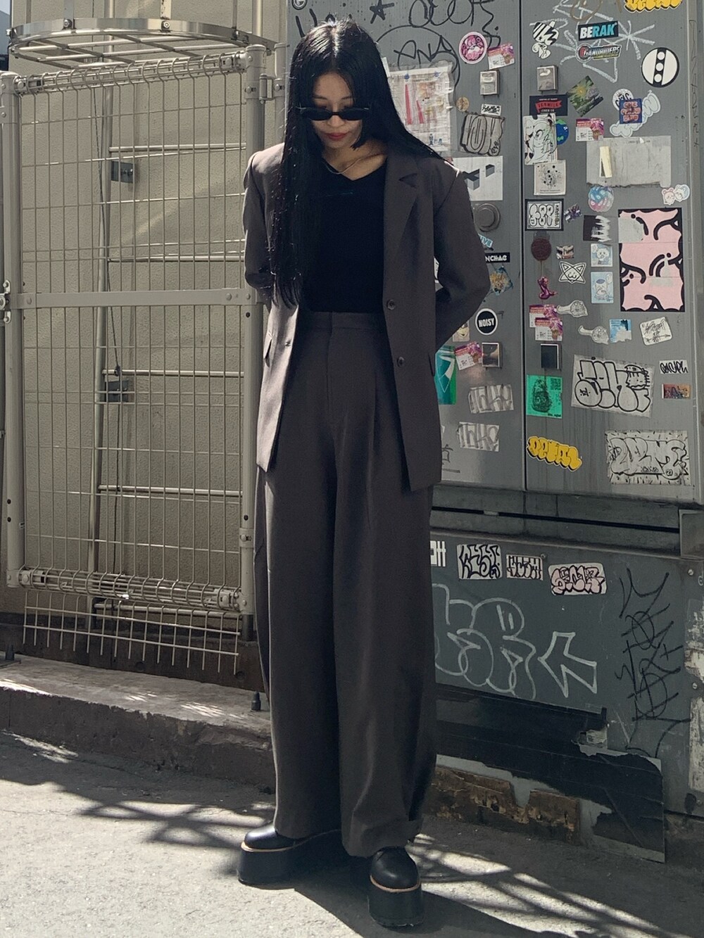 グレー系のテーラードジャケット、グレー系のその他パンツ、ブラック系のブーツを着用したレディースの秋コーディネートの2枚目の写真