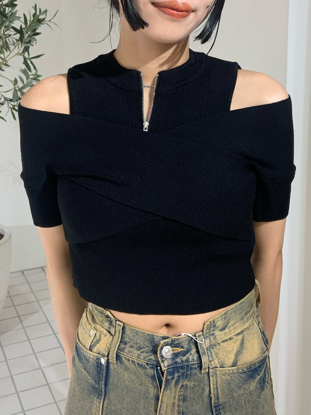 ブラック系のニット/セーター、ブラック系のデニムパンツ、ブラック系のサンダルを着用したレディースの夏コーディネートの5枚目の写真