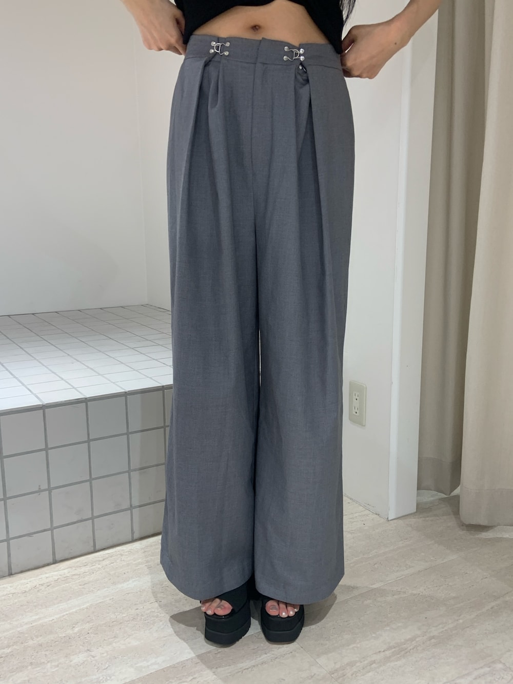 ブルー系のニット/セーター、グレー系のその他パンツ、ブラック系のサンダルを着用したレディースの夏コーディネートの6枚目の写真