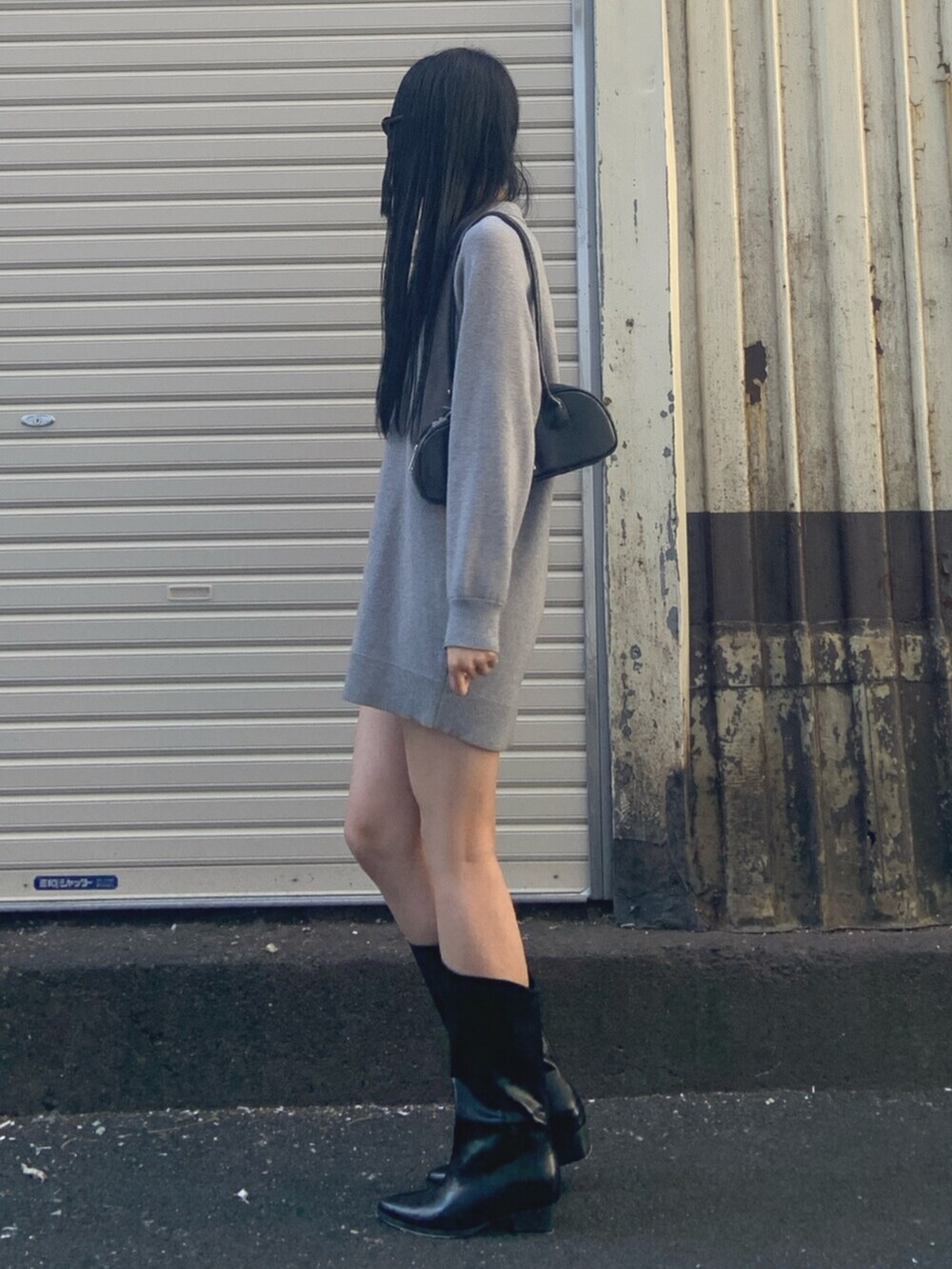 ブラック系のボストンバッグ、グレー系のワンピース、ブラック系のブーツを着用したレディースの冬コーディネートの3枚目の写真