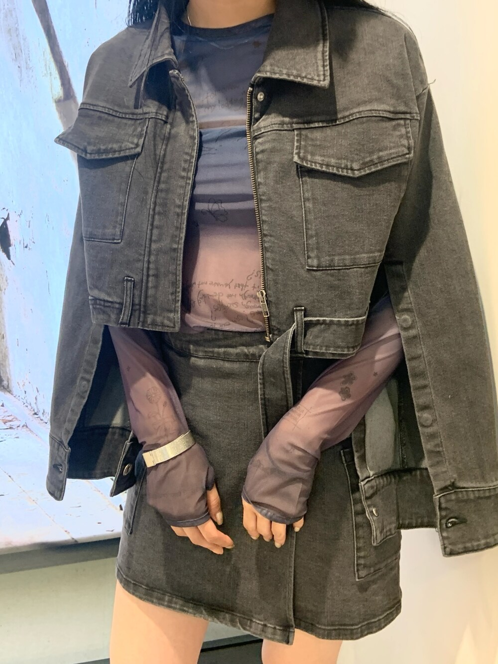 ブラック系のデニムジャケット、ブルー系のTシャツ/カットソー、ブラック系のスカートを着用したレディースの秋コーディネートの5枚目の写真