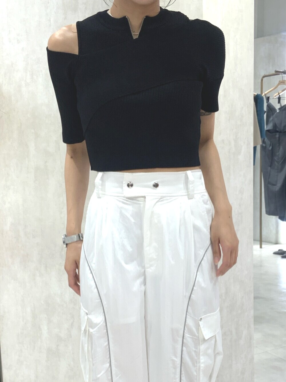 ブラック系のサンダル、ブラック系のニット/セーター、ホワイト系のカーゴパンツを着用したレディースの春コーディネートの5枚目の写真