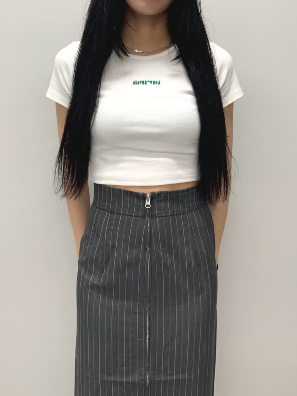 ブラック系のサンダル、ホワイト系のTシャツ/カットソー、グレー系のスカートを着用したレディースの春コーディネートの6枚目の写真