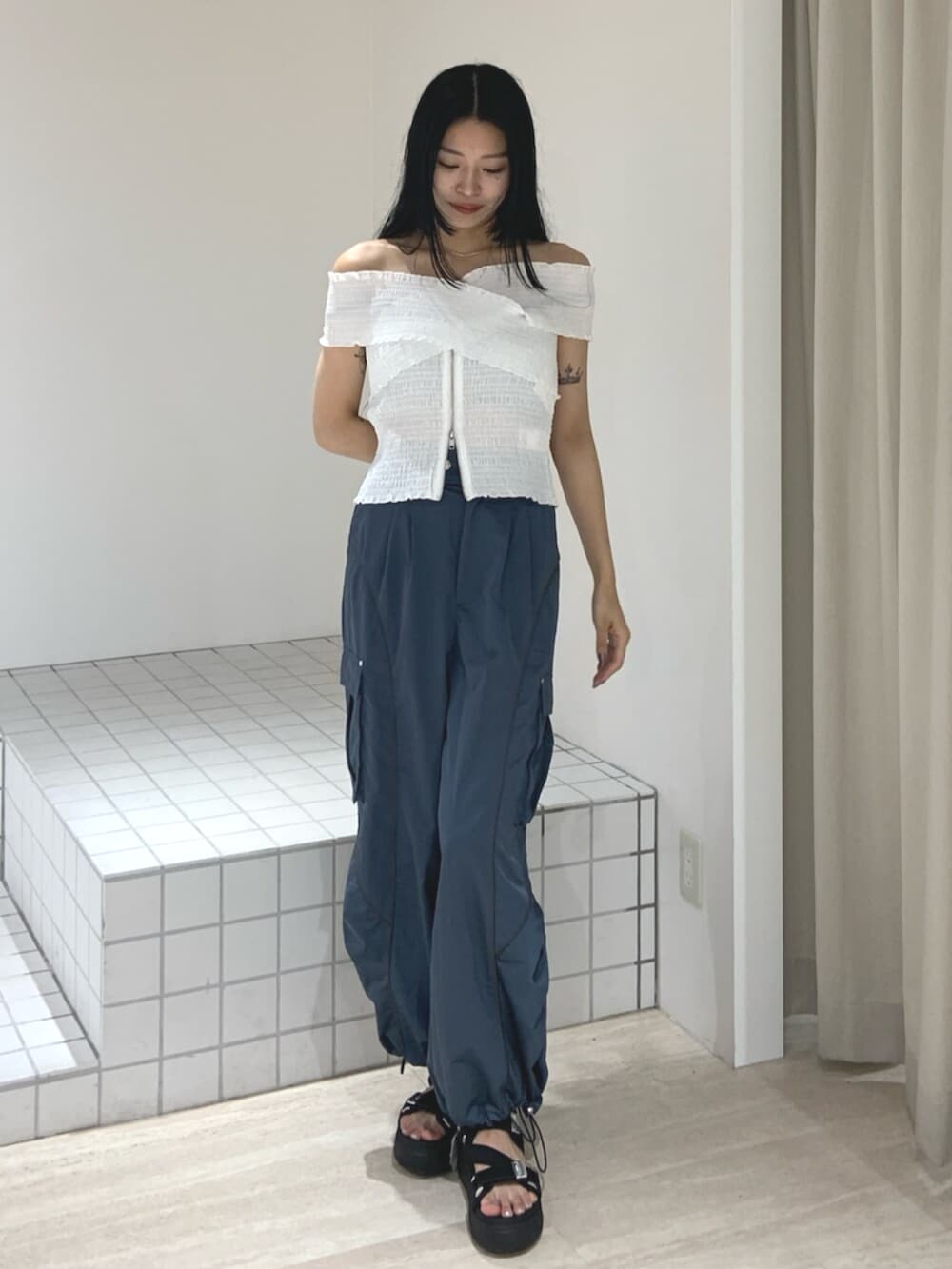 ブラック系のサンダル、ホワイト系のシャツ/ブラウス、ブルー系のカーゴパンツを着用したレディースの夏コーディネートの2枚目の写真