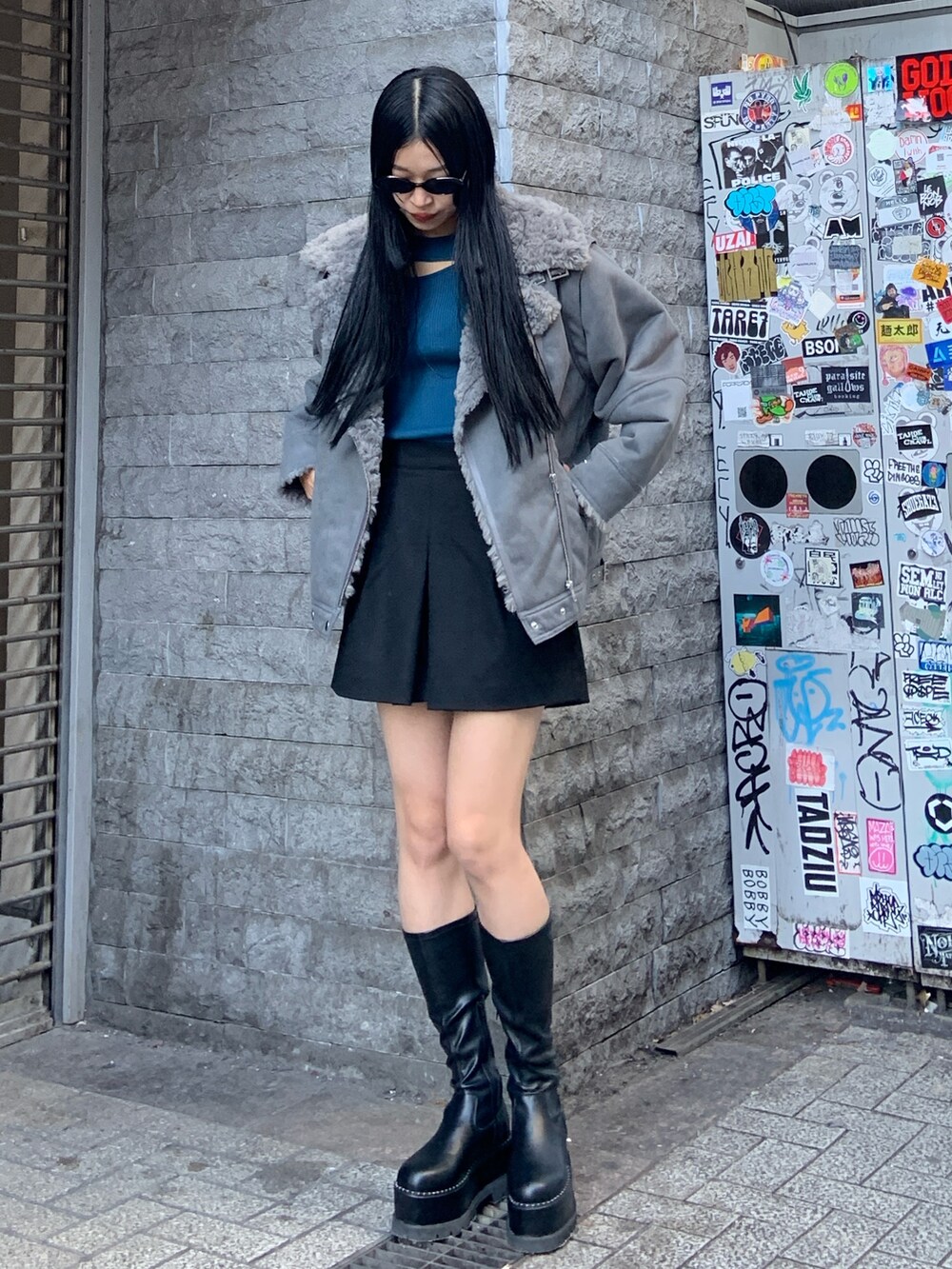 グレー系のムートンコート、ブルー系のニット/セーター、ブラック系のその他パンツを着用したレディースの冬コーディネートの2枚目の写真