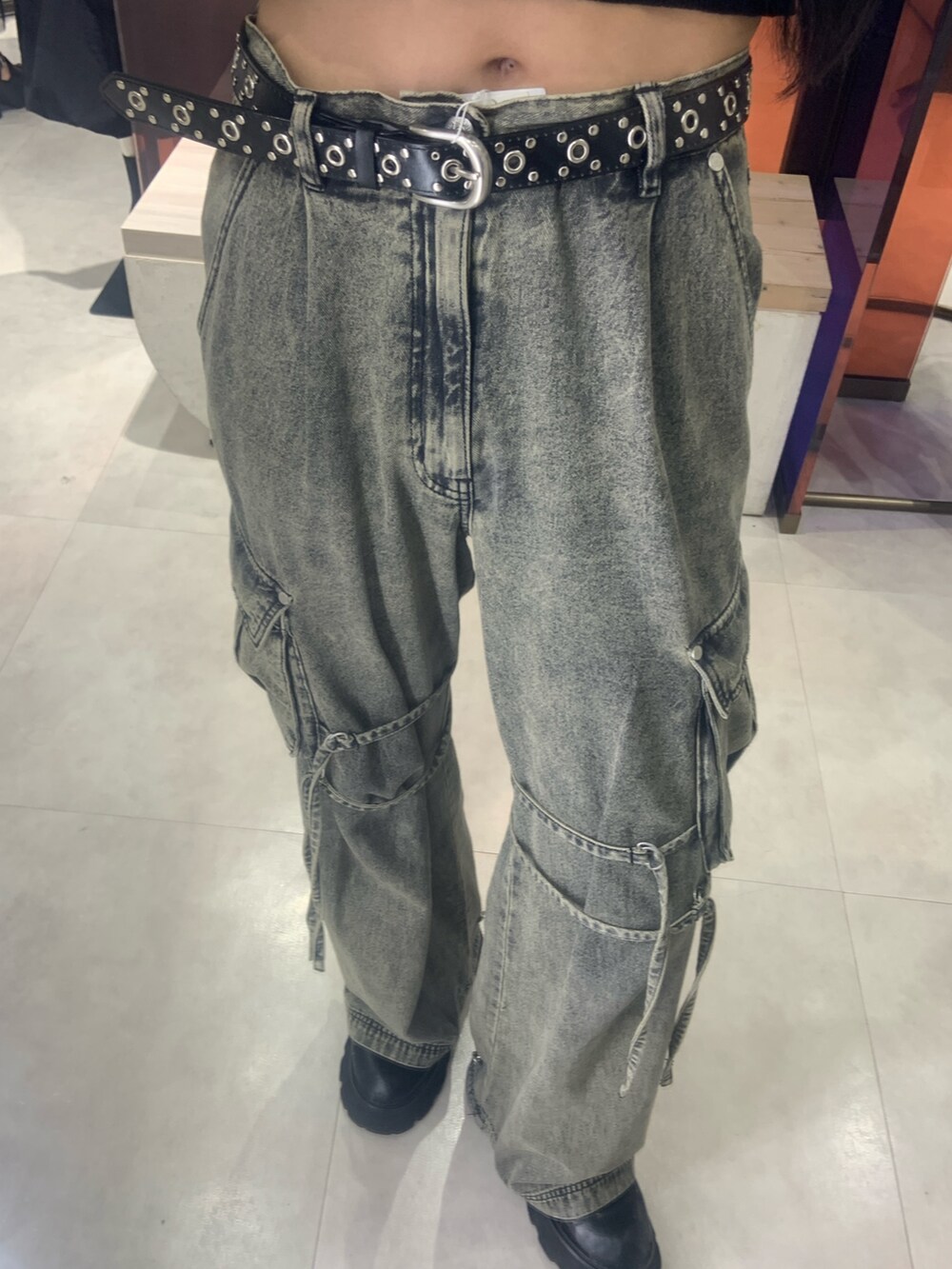ブラック系のニット/セーター、ブラック系のデニムパンツ、ブラック系のベルトを着用したレディースの春コーディネートの4枚目の写真