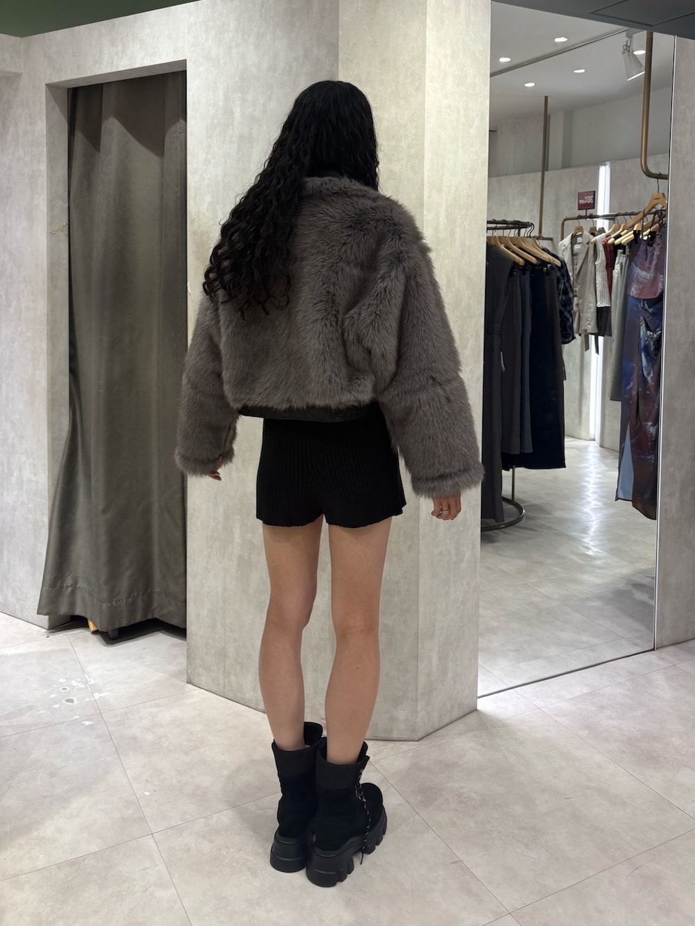 ブラック系のムートンコート、ブラック系のTシャツ/カットソー、ブラック系のその他パンツを着用したレディースの夏コーディネートの3枚目の写真