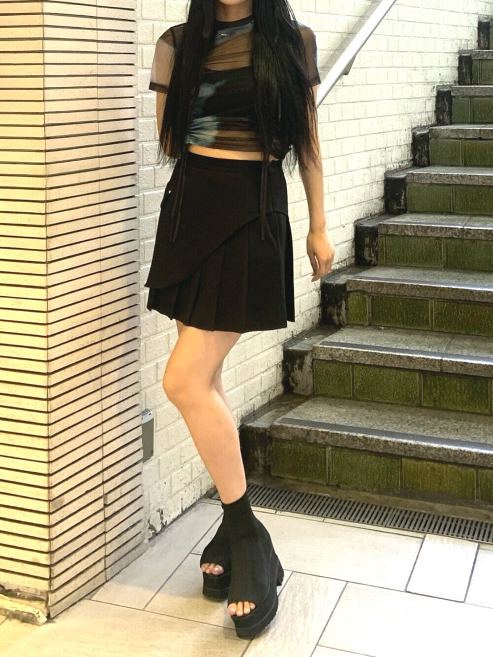 ブラック系のサンダル、その他のTシャツ/カットソー、ブラック系のスカートを着用したレディースの夏コーディネートの5枚目の写真
