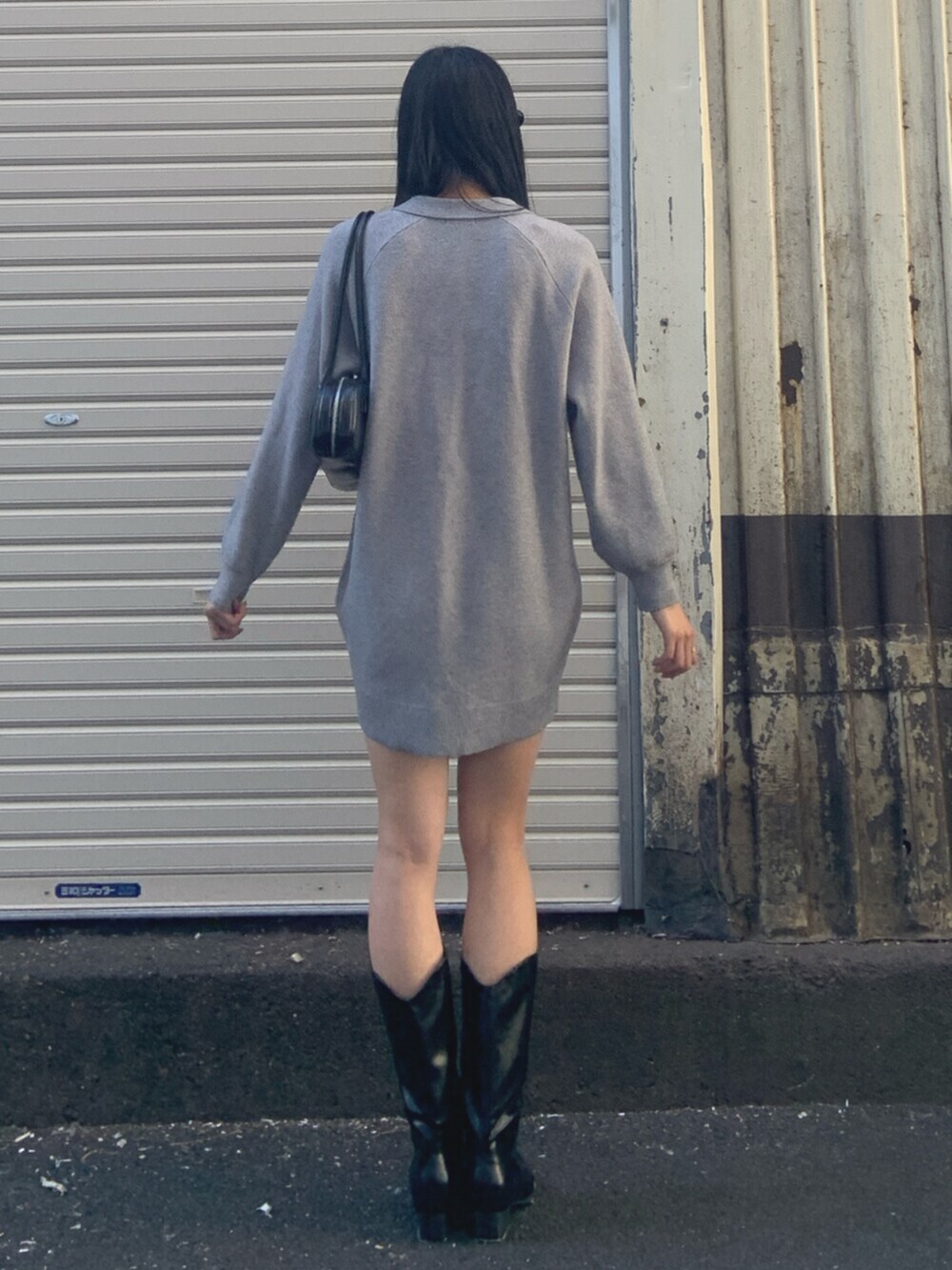 ブラック系のボストンバッグ、グレー系のワンピース、ブラック系のブーツを着用したレディースの冬コーディネートの4枚目の写真