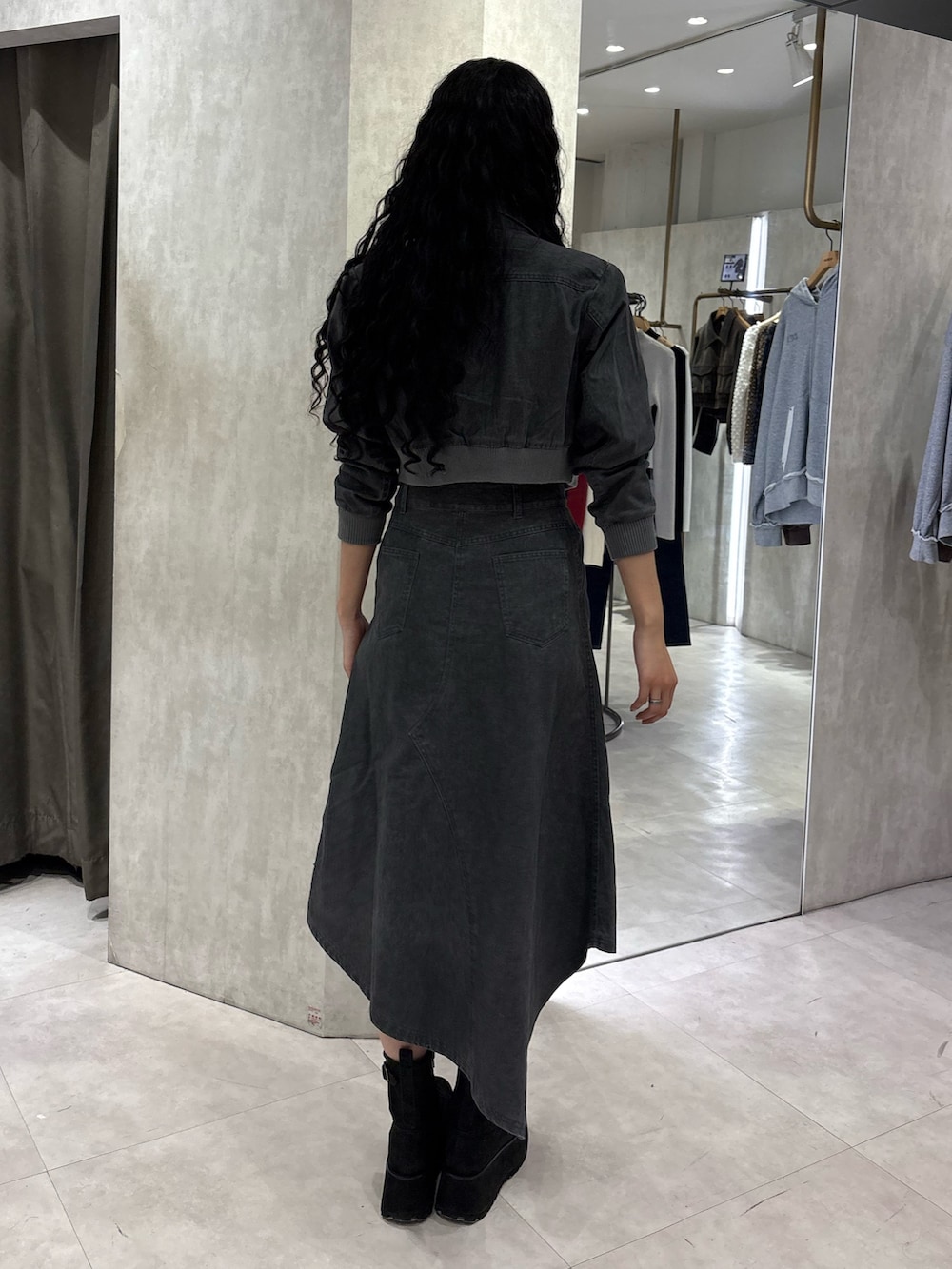 グレー系のブルゾン、ブラック系のキャミソール、グレー系のスカートを着用したレディースの春コーディネートの3枚目の写真