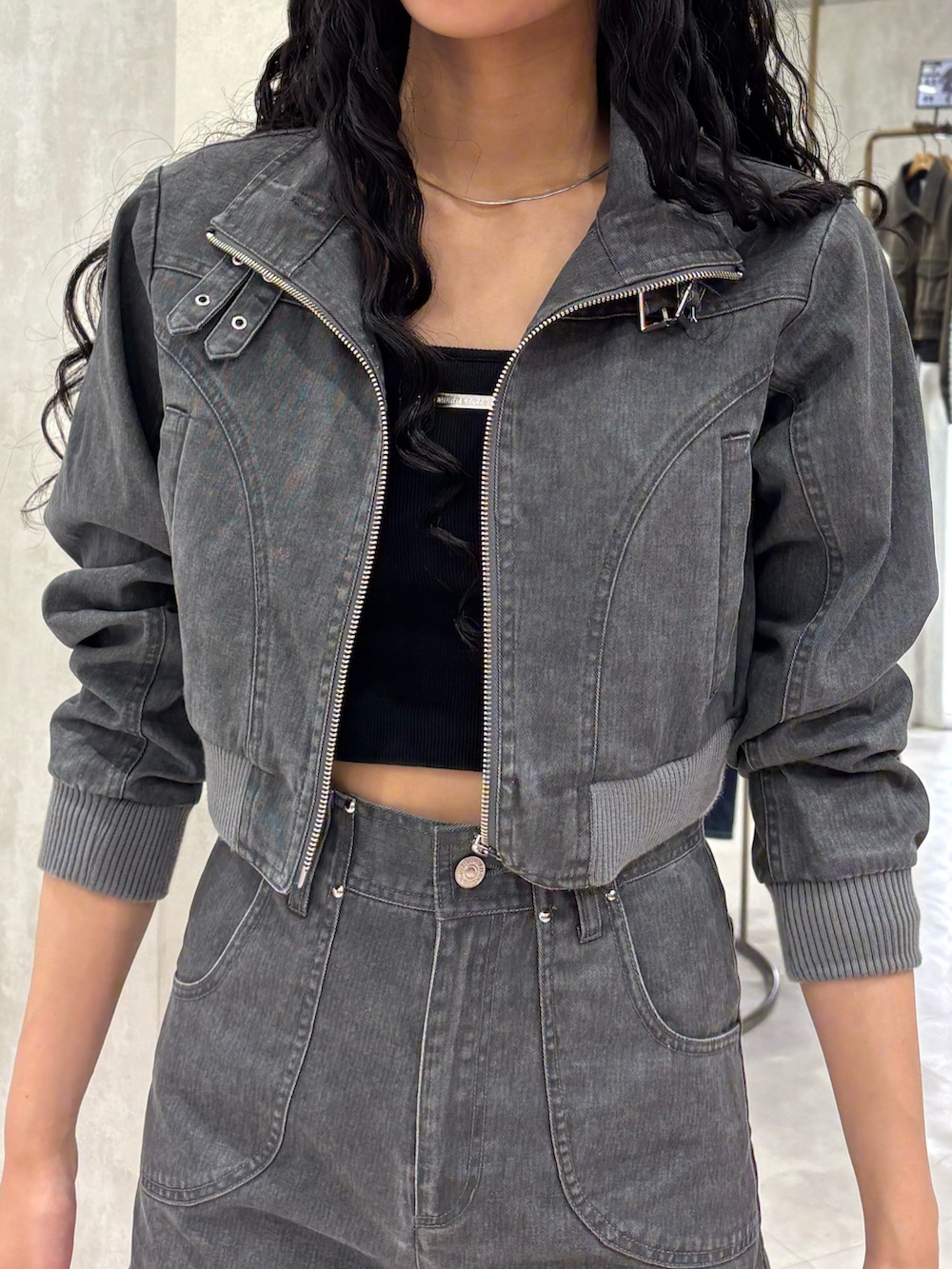 グレー系のブルゾン、ブラック系のキャミソール、グレー系のスカートを着用したレディースの春コーディネートの4枚目の写真