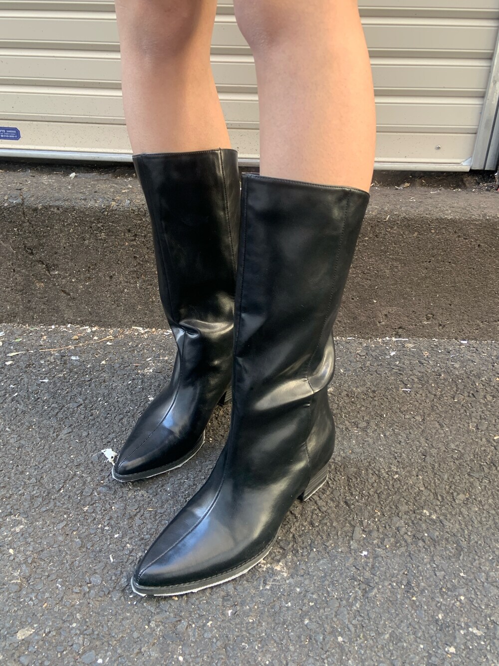 ブラック系のニット/セーター、ブラック系のスカート、ブラック系のブーツを着用したレディースの冬コーディネートの6枚目の写真