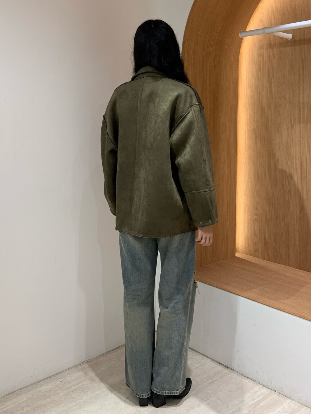 ブルー系のデニムパンツ、グリーン系のテーラードジャケットを着用したレディースの秋コーディネートの4枚目の写真