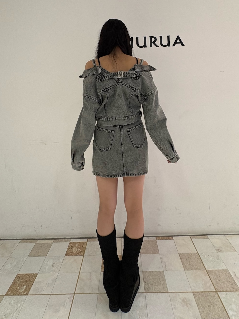 グリーン系のデニムジャケット、グリーン系のデニムスカート、ブラック系のブーツを着用したレディースの冬コーディネートの3枚目の写真