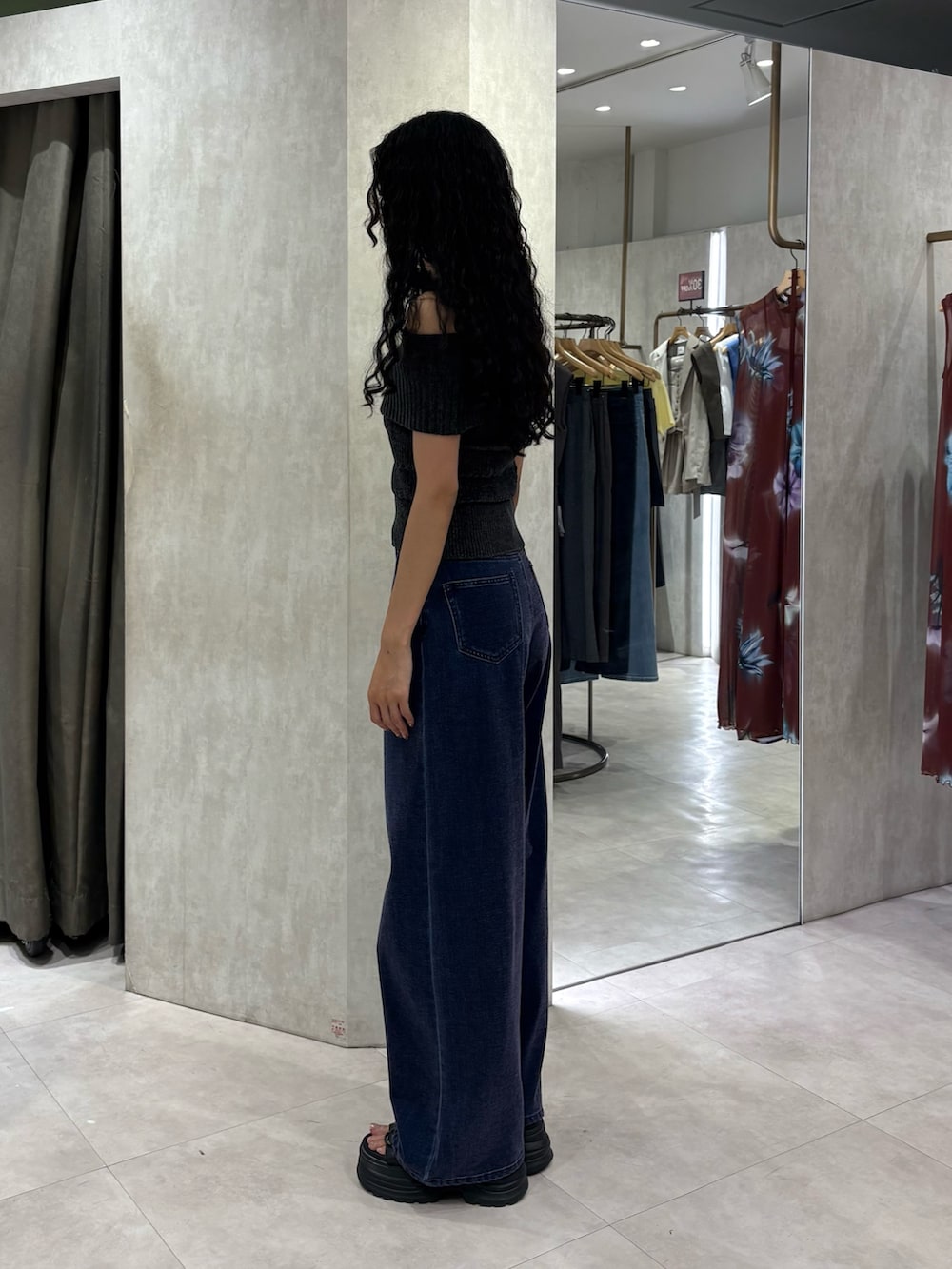 グレー系のニット/セーター、パープル系のデニムパンツ、ブラック系のサンダルを着用したレディースの夏コーディネートの2枚目の写真