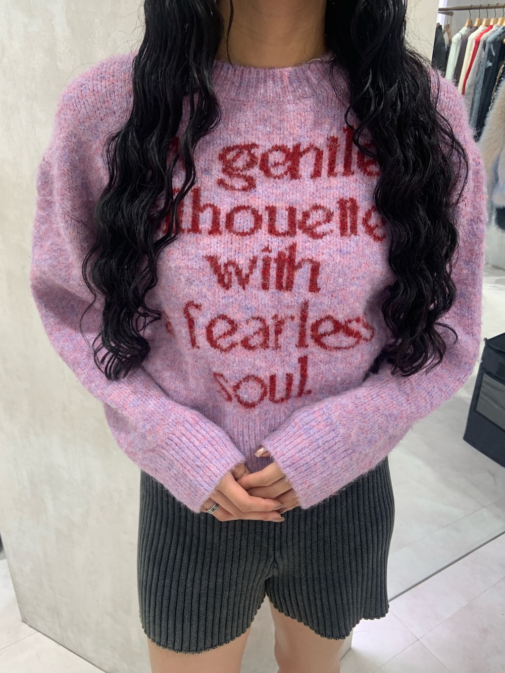 ピンク系のニット/セーター、ブルー系のその他パンツ、ブラック系のブーツを着用したレディースの秋コーディネートの4枚目の写真