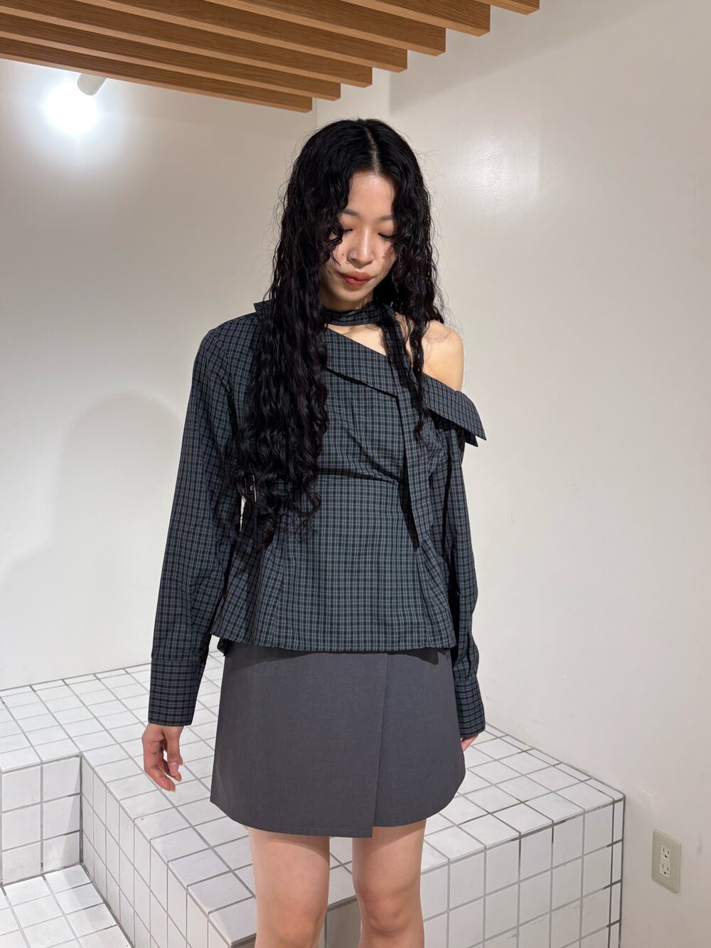 グレー系のシャツ/ブラウス、グレー系のスカート、ブラック系のブーツを着用したレディースの春コーディネートの4枚目の写真