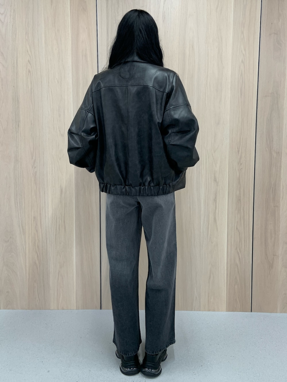 ブラック系のブルゾン、ブラック系のブーツ、ベージュ系のTシャツ/カットソーを着用したレディースの春コーディネートの4枚目の写真