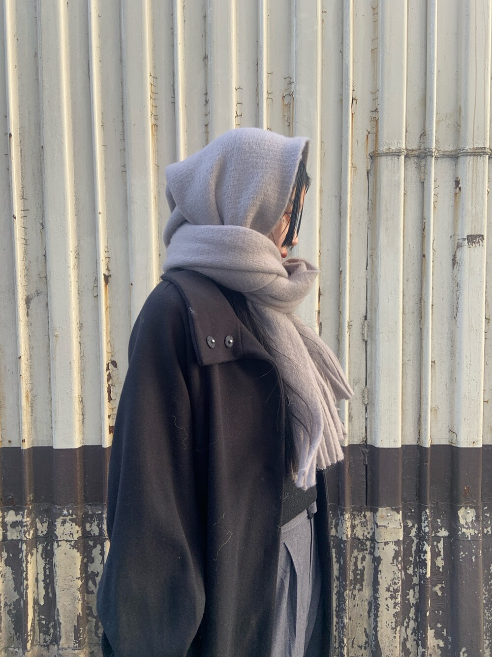 ブラック系のその他アウター、グレー系のその他パンツ、グレー系のマフラーを着用したレディースの冬コーディネートの5枚目の写真