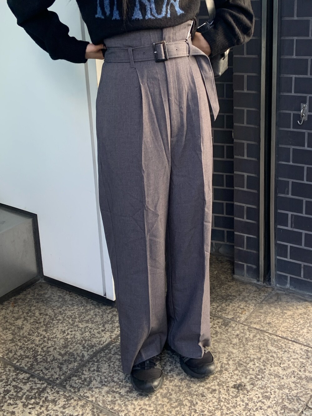 ブラック系のニット/セーター、グレー系のその他パンツ、ブラック系のムートンコートを着用したレディースの冬コーディネートの8枚目の写真