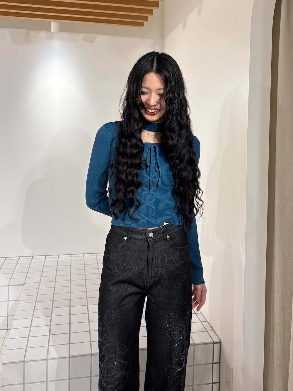 ブルー系のニット/セーター、ブラック系のデニムパンツを着用したレディースの冬コーディネートの4枚目の写真