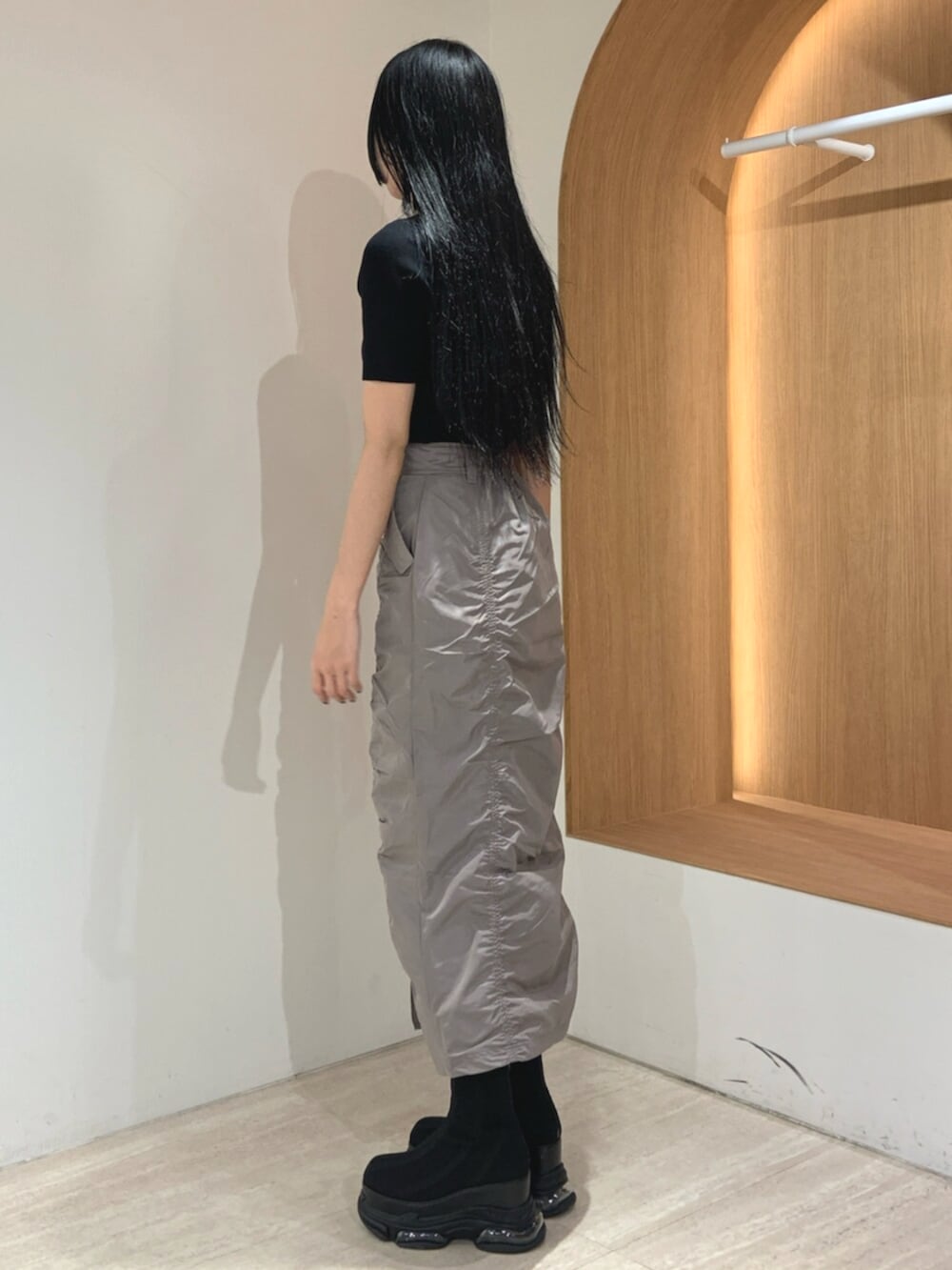 ブラック系のブーツ、ブラック系のニット/セーター、グレー系のスカートを着用したレディースの春コーディネートの3枚目の写真