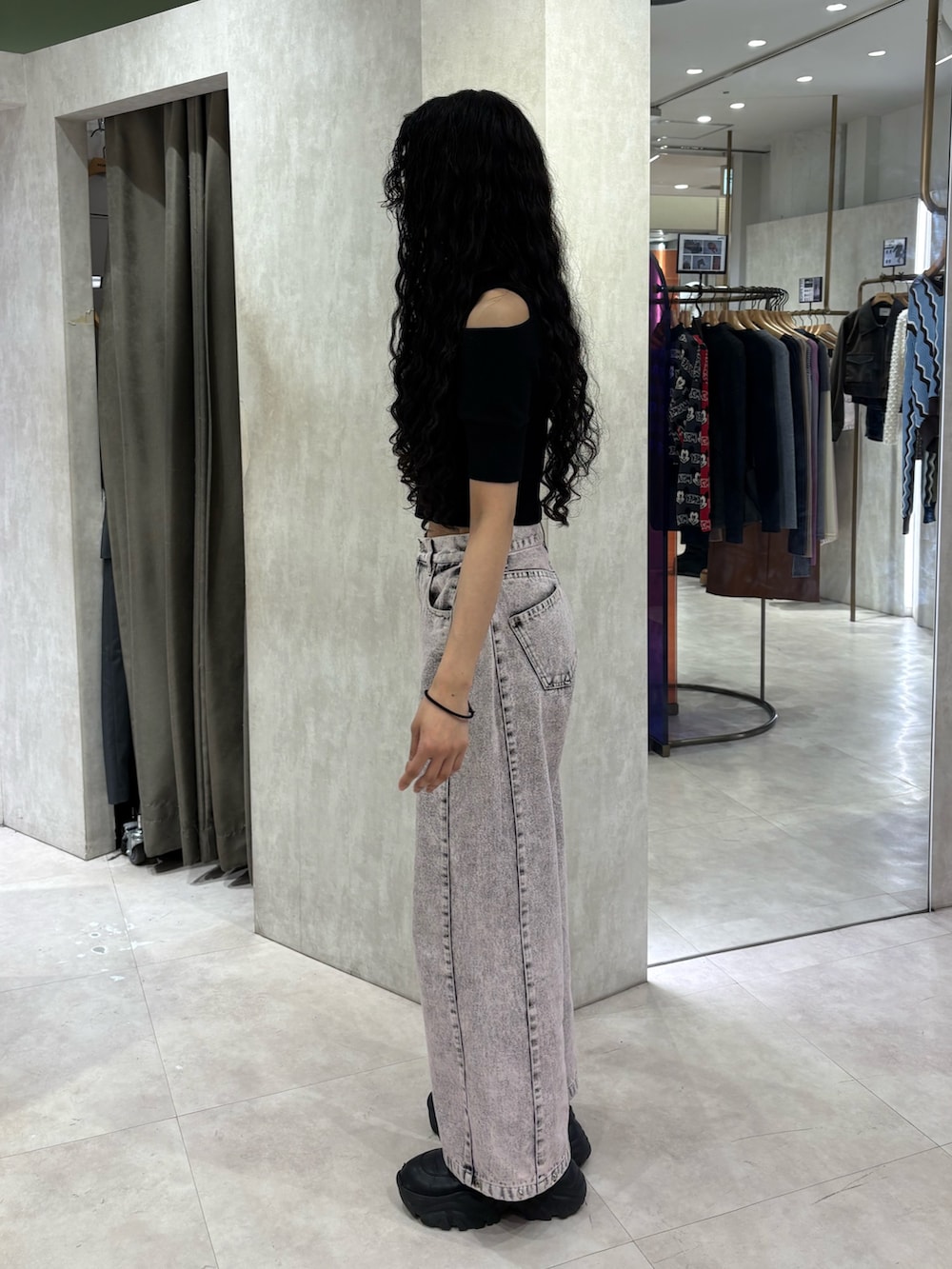 ブラック系のニット/セーター、ピンク系のデニムパンツを着用したレディースの春コーディネートの2枚目の写真