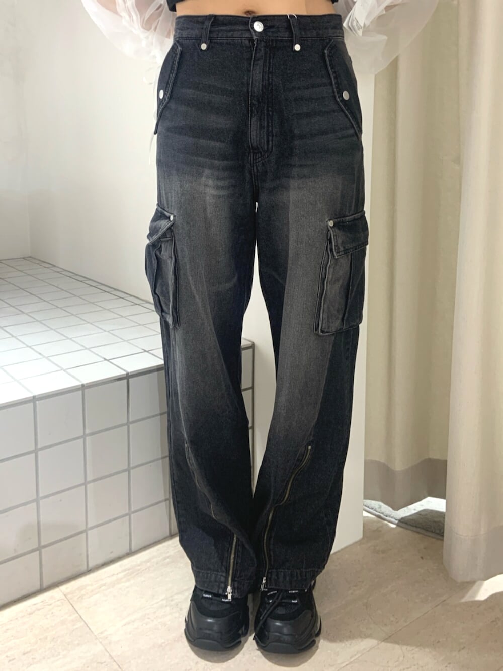 ブルー系のTシャツ/カットソー、ブラック系のデニムパンツ、ブラック系のスニーカーを着用したレディースの春コーディネートの5枚目の写真