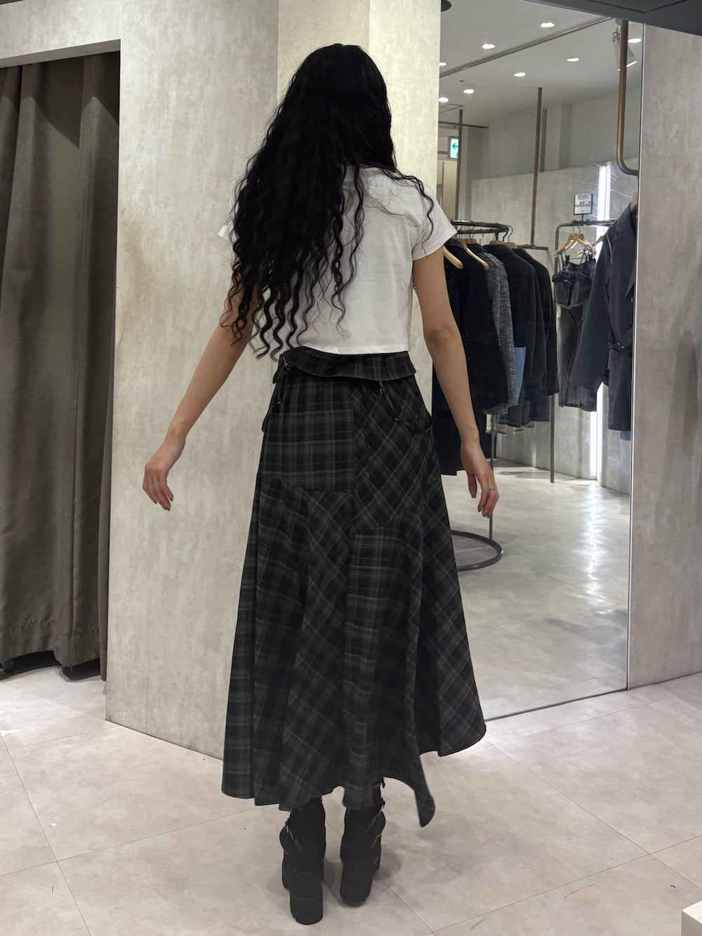 ホワイト系のTシャツ/カットソー、ブラック系のワンピース、ブラック系のブーツを着用したレディースの春コーディネートの3枚目の写真