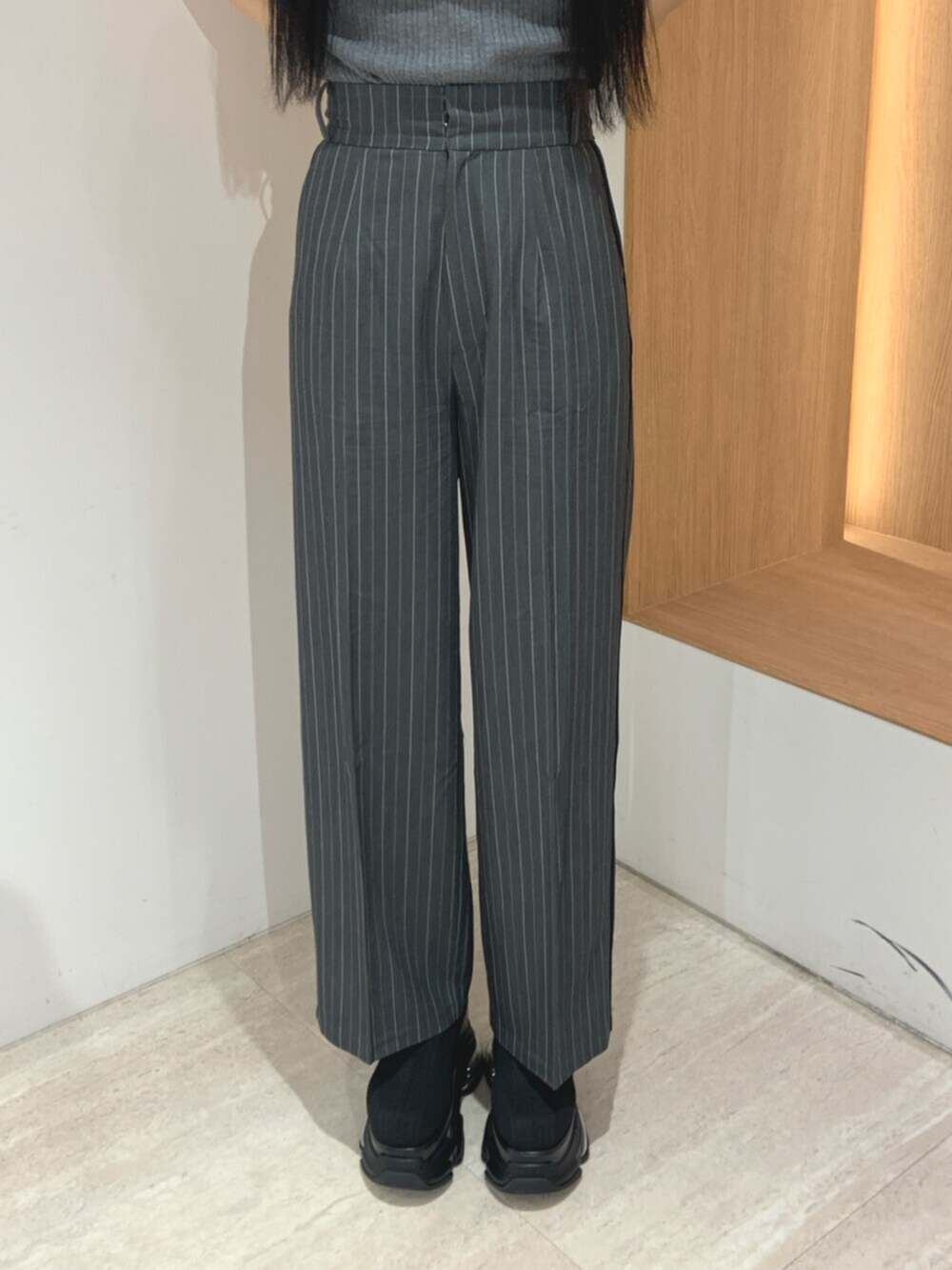 ブラック系のブーツ、グレー系のニット/セーター、グレー系のスラックスを着用したレディースの春コーディネートの6枚目の写真