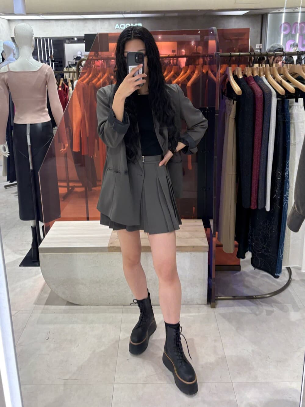 ブラック系のブーツ、グレー系のテーラードジャケット、グレー系のスカートを着用したレディースの冬コーディネートの2枚目の写真