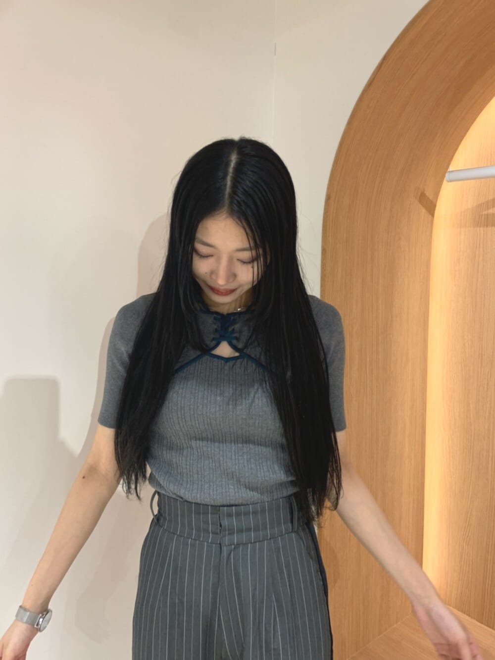 ブラック系のブーツ、グレー系のニット/セーター、グレー系のスラックスを着用したレディースの春コーディネートの5枚目の写真