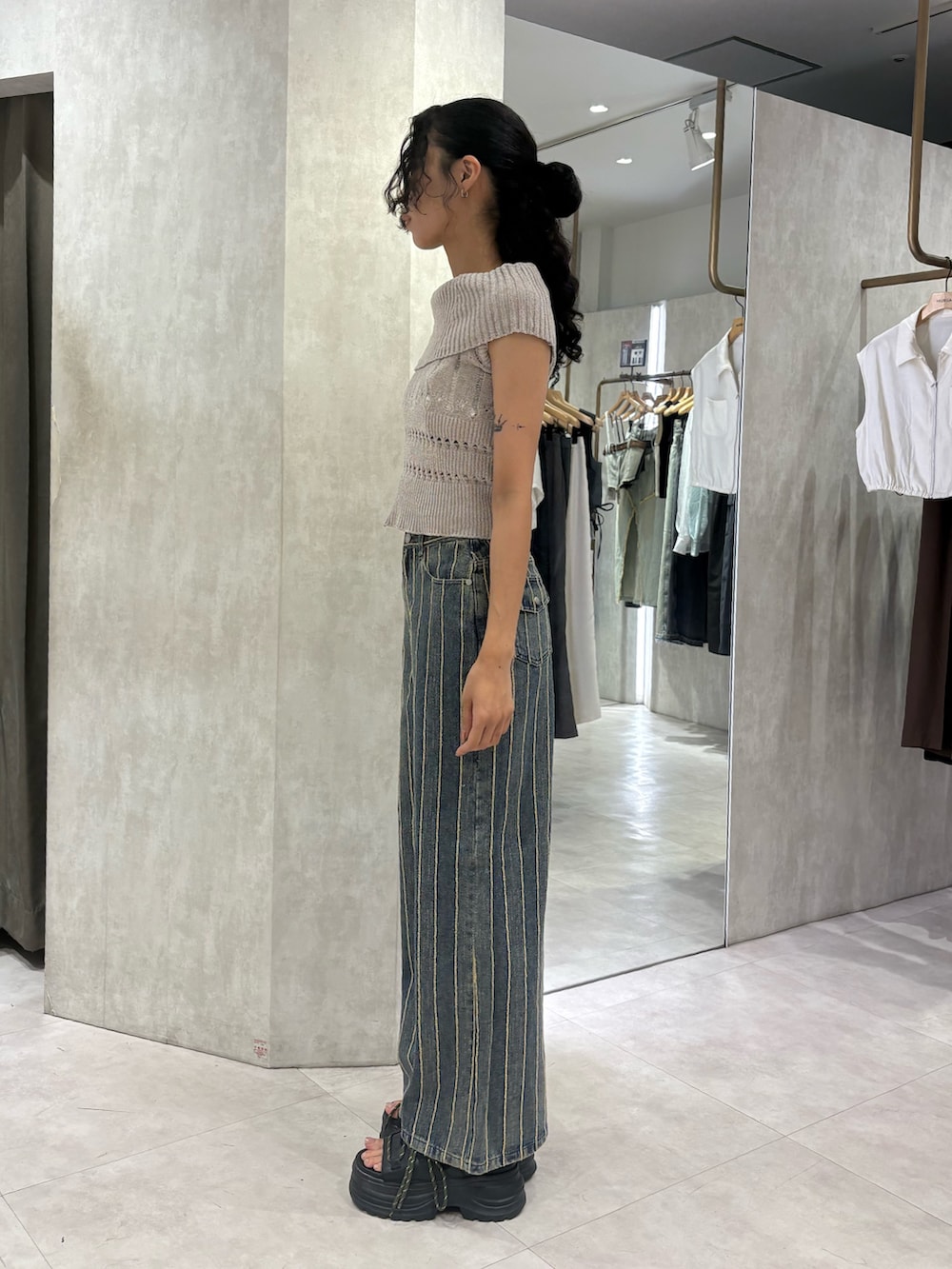 ベージュ系のニット/セーター、ブルー系のデニムパンツ、ブラック系のサンダルを着用したレディースの夏コーディネートの2枚目の写真