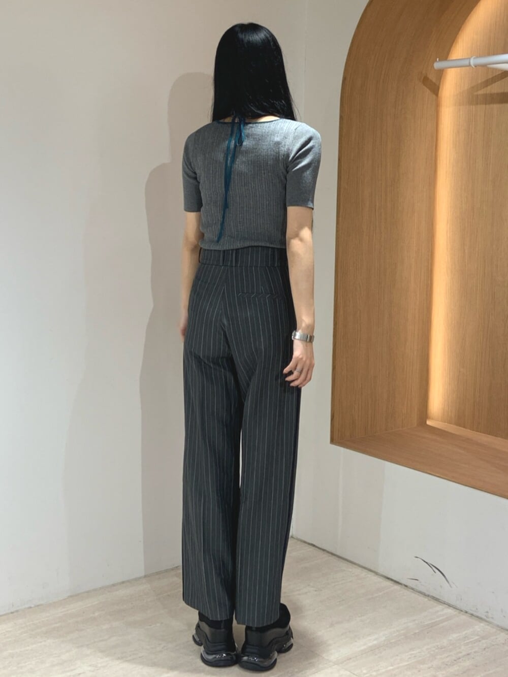 ブラック系のブーツ、グレー系のニット/セーター、グレー系のスラックスを着用したレディースの春コーディネートの4枚目の写真