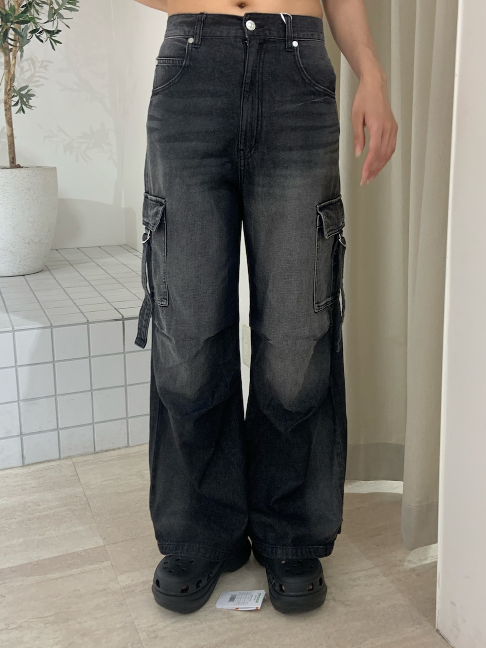 ブラック系のニット/セーター、ブラック系のデニムパンツ、ブラック系のサンダルを着用したレディースの夏コーディネートの6枚目の写真