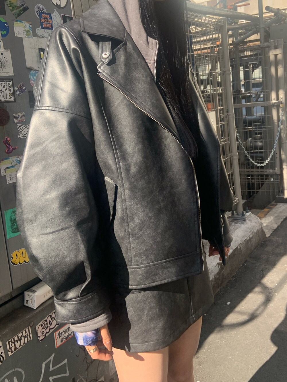 ブラック系のブルゾン、ブラック系のスカート、グレー系のパーカーを着用したレディースの冬コーディネートの5枚目の写真