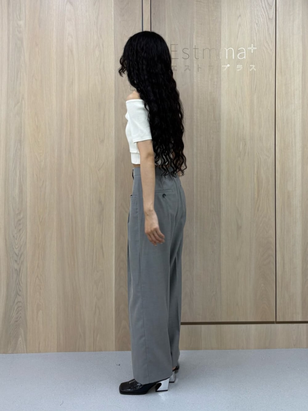 ブラック系のパンプス、グレー系のスラックス、ホワイト系のニット/セーターを着用したレディースの夏コーディネートの2枚目の写真
