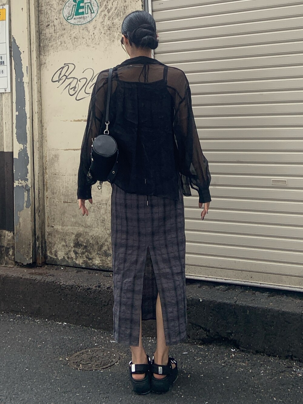 ブラック系のサンダル、グレー系のワンピース、ブラック系のハンドバッグを着用したレディースの春コーディネートの4枚目の写真