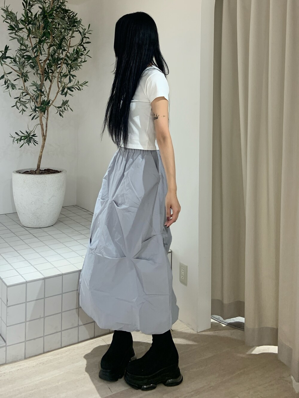 ホワイト系のTシャツ/カットソー、ブルー系のスカート、ブラック系のブーツを着用したレディースの春コーディネートの3枚目の写真